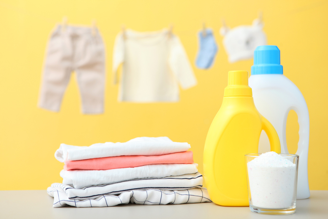 Baby clothes and detergents on the table. Baby clothes care concept.